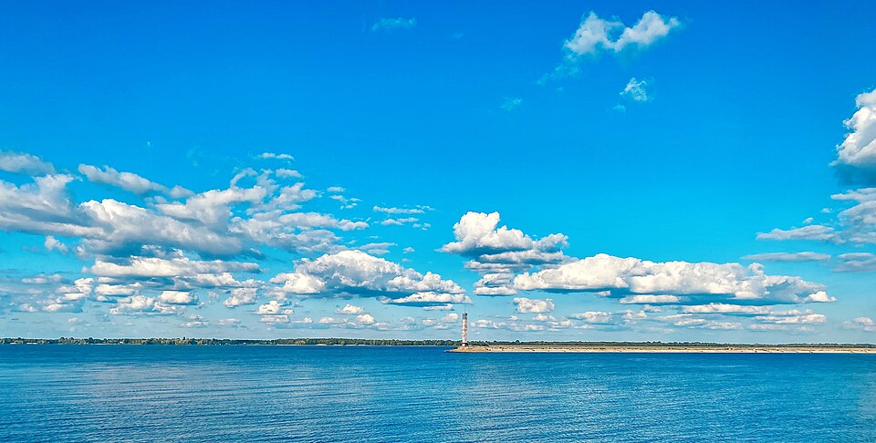 Київське водосховище біля Вишгорода: широка відкрита вода, низький піщаний берег удалині й навігаційна башта на косі