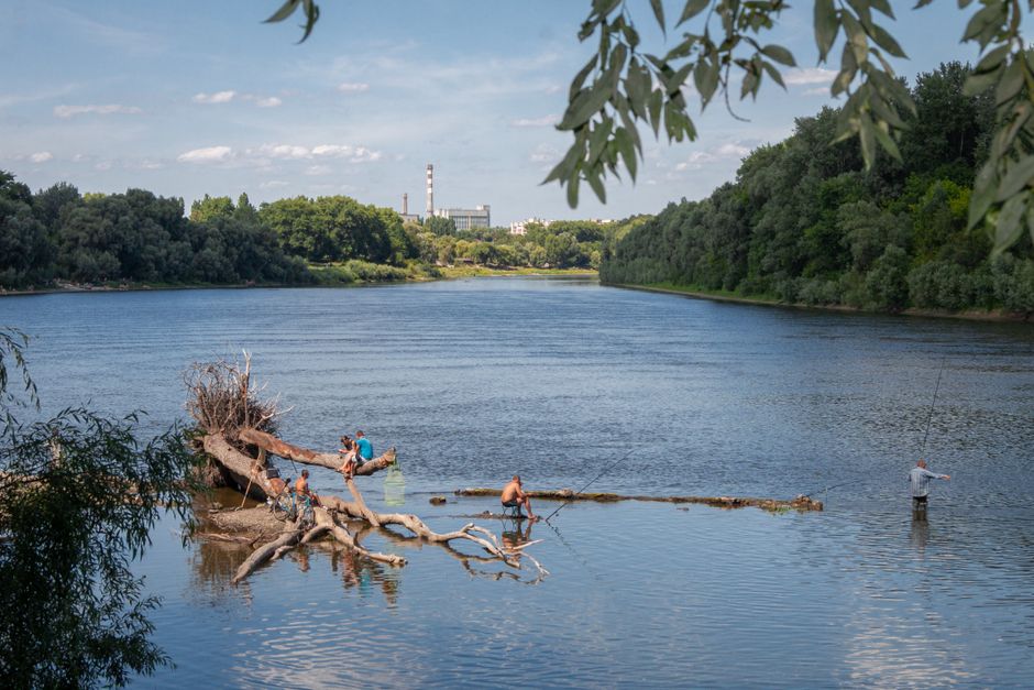 Широкая равнинная река с лесистыми берегами, рыбаки у коряги