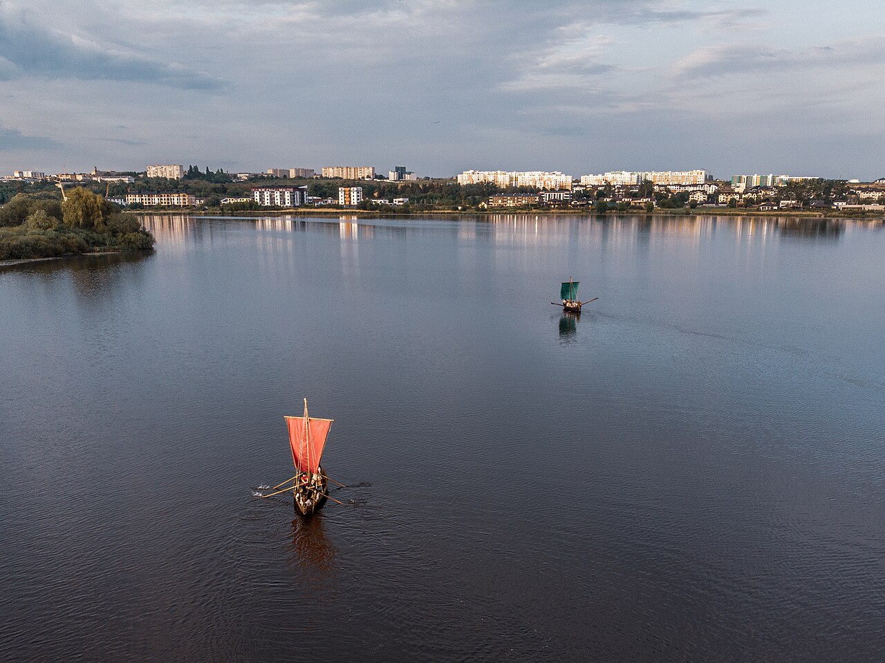 Озеро Басов Кут в Ровно: широкое зеркало воды, лодки под парусами, зелёный берег и жилая застройка на горизонте